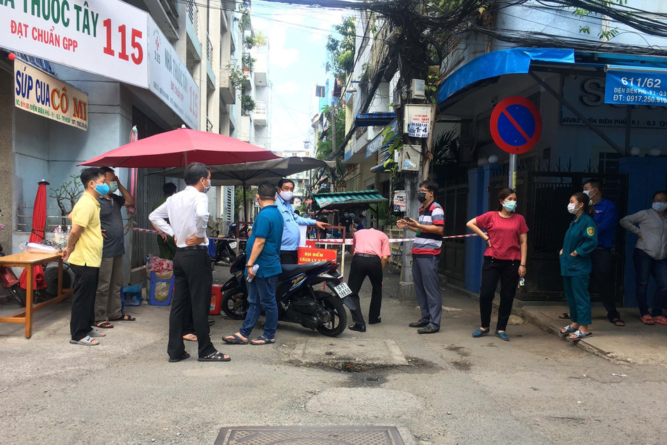 Các lực lượng chức năng phong tỏa giám sát khu vực cách ly tại hẻm 611 đường Điện Biên Phủ, phường 1, Quận 3. (Ảnh: Thanh Vũ/TTXVN)