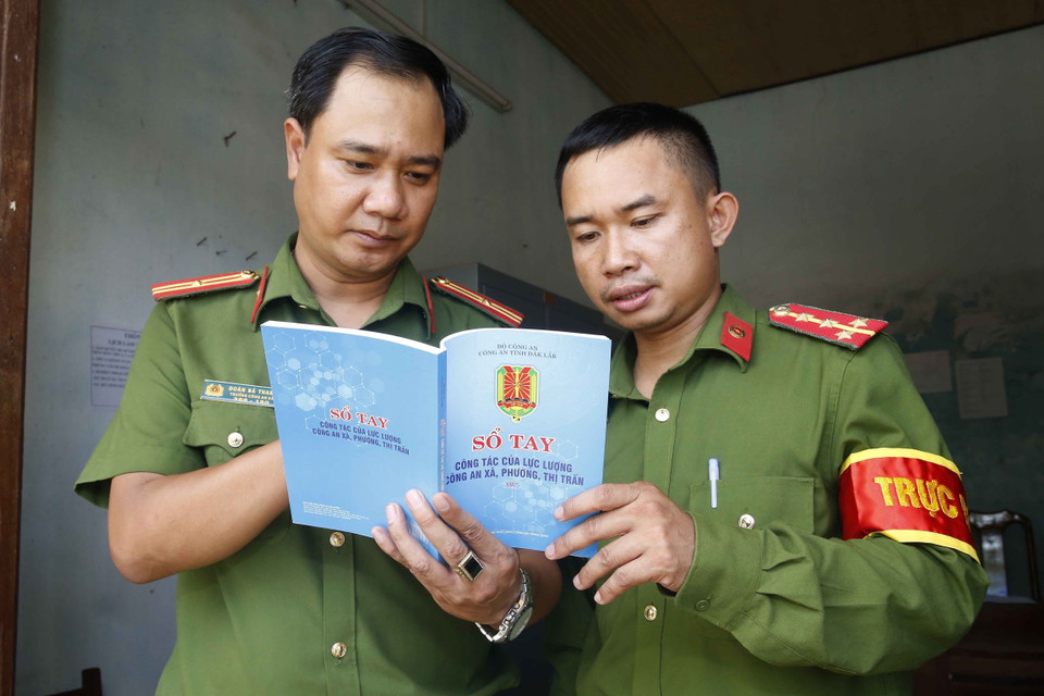 Công an chính quy xã Xã Ea Lê, huyện Ea Súp tỉnh Đắk Lắk trao đổi nghiệp vụ từ cuốn sổ tay công tác của lực lượng công an xã, phường, thị trấn. (Ảnh: Doãn Tấn/TTXVN)