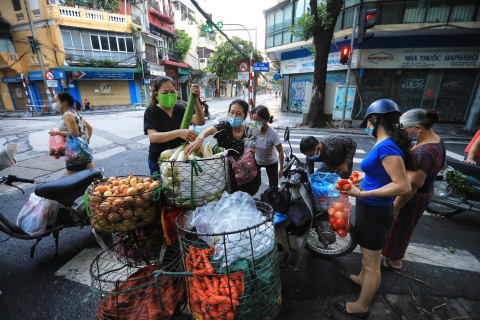 Chỉ thị 17 ban hành vào đêm muộn nên nhiều người không biết, vẫn đi tập thể dục sớm trên phố Hàng Trống và tranh thủ đi chợ, không đảm bảo giãn khoảng cách cần thiết phòng chống dịch (Ảnh chụp lúc 6h15 sáng 24/7). (Ảnh: Thành Đạt/TTXVN)