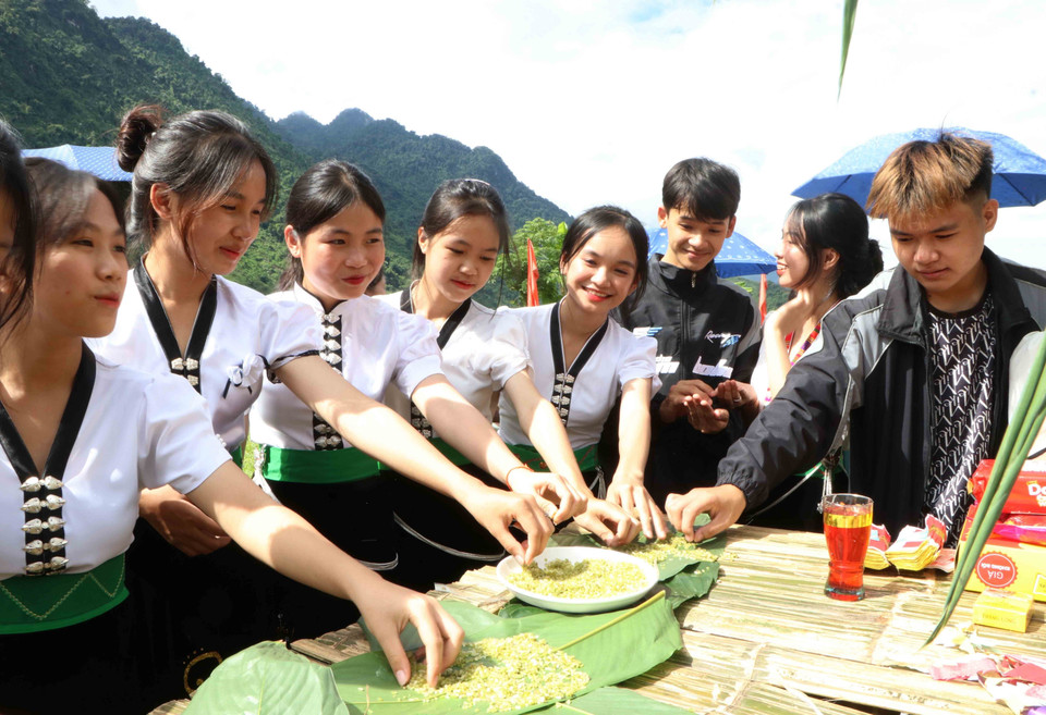 Người dân và du khách thưởng thức cốm tại lễ hội. (Ảnh: Nguyễn Oanh/TTXVN)