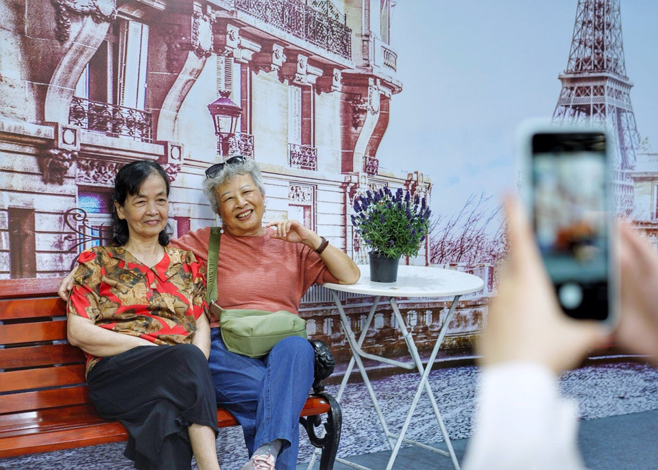 Không chỉ giới trẻ mà những người cao tuổi cũng tranh thủ check-in. (Ảnh: Nhật Lam/Vietnam+)