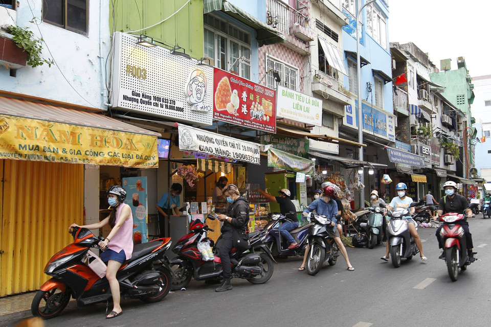 Vẫn còn tình trạng tập trung đông người mua trà sữa trên đường Nguyễn Thượng Hiền, Quận 3 trước giờ thực hiện giãn cách. (Ảnh: Thanh Vũ/TTXVN)