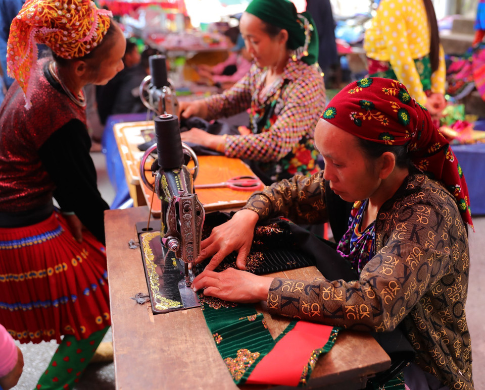 Chợ phiên là nơi nhiều bà con đến để may vá, sửa chữa trang phục. (Ảnh: Hoàng Hiếu/TTXVN)