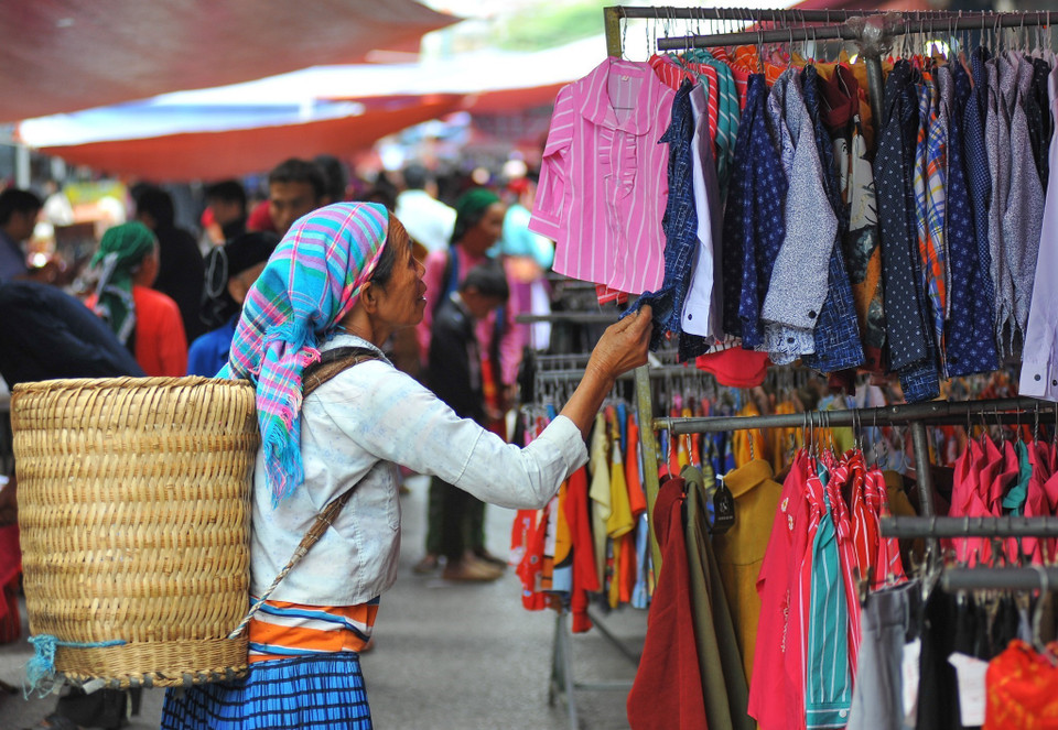 Người dân tìm, mua sắm quần áo tại chợ. (Ảnh: Hoàng Hiếu/TTXVN)