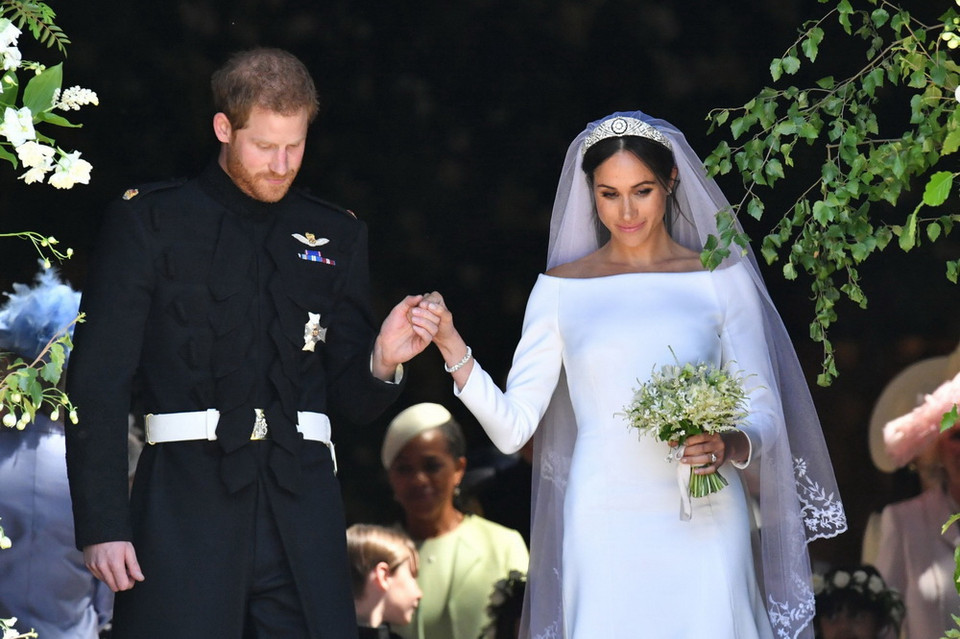 Sau nghi lễ trong nhà nguyện, Hoàng tử Harry (trái) và hôn phu Meghan lên xe ngựa thực hiện lễ rước quanh tòa lâu đài và chào dân chúng trên đường phố. (AFP/TTXVN)