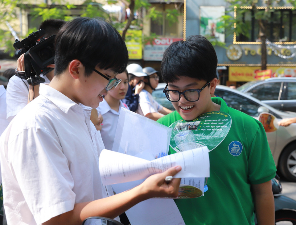 Các sỹ tử Thủ đô đối chiếu đáp án của các mã đề môn thi Ngoại ngữ. (Ảnh: PV/Vietnam+)