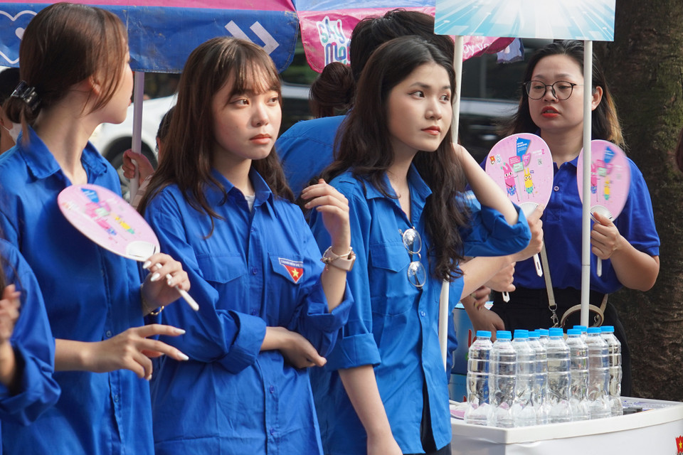 Đội ngũ tình nguyện viên hỗ trợ thí sinh bên ngoài cổng trường. (Ảnh: PV/Vietnam+)