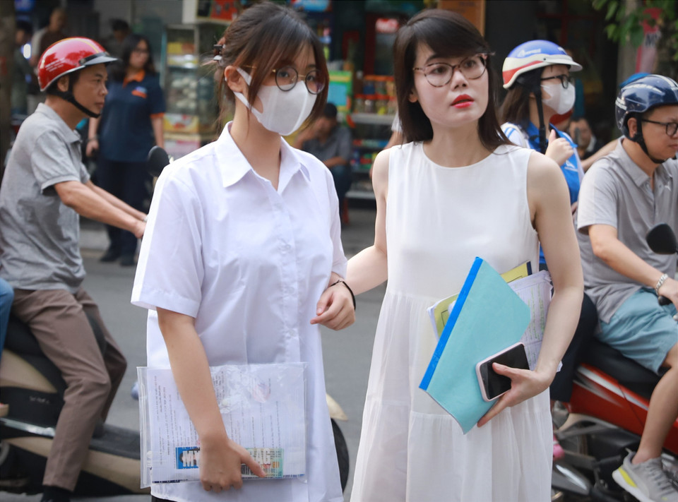 Nhiều phụ huynh đưa con đến từ sớm để tranh thủ dặn dò con trước kỳ thi quan trọng. (Ảnh: PV/Vietnam+)