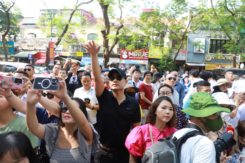 Bên ngoài cổng trường, các bậc phụ huynh hồi hộp chờ đợi con em kết thúc ngày thi đầu tiên. (Ảnh: PV/Vietnam+)