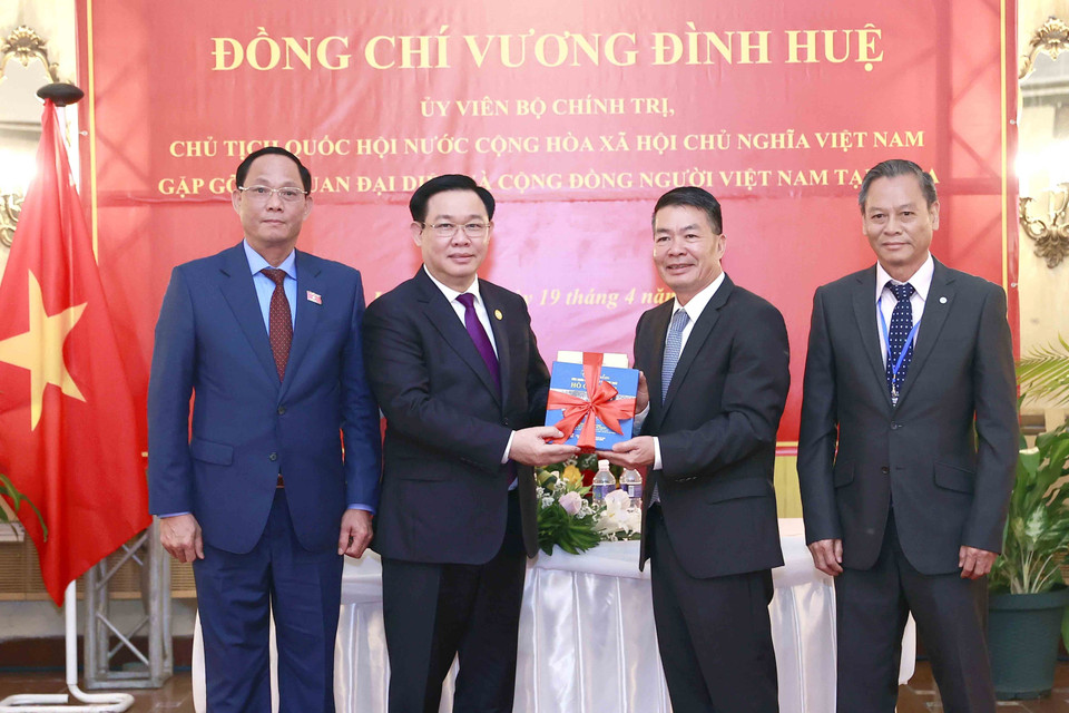 Chủ tịch Quốc hội Vương Đình Huệ trao tập sách tượng trưng (tủ sách về Bác Hồ) cho Đại sứ và đại diện cộng đồng. (Ảnh: Doãn Tấn/TTXVN)