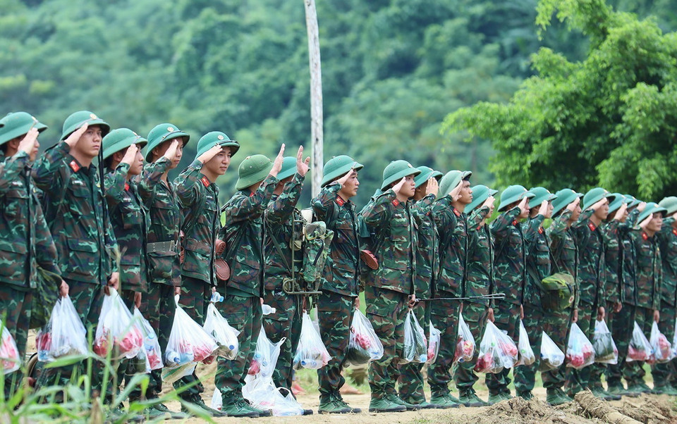 Các chiến sỹ thuộc Trung đoàn 98, Sư đoàn 316 chào bà con nhân dân thôn Làng Nủ trước khi về đơn vị. (Ảnh: TTXVN phát)