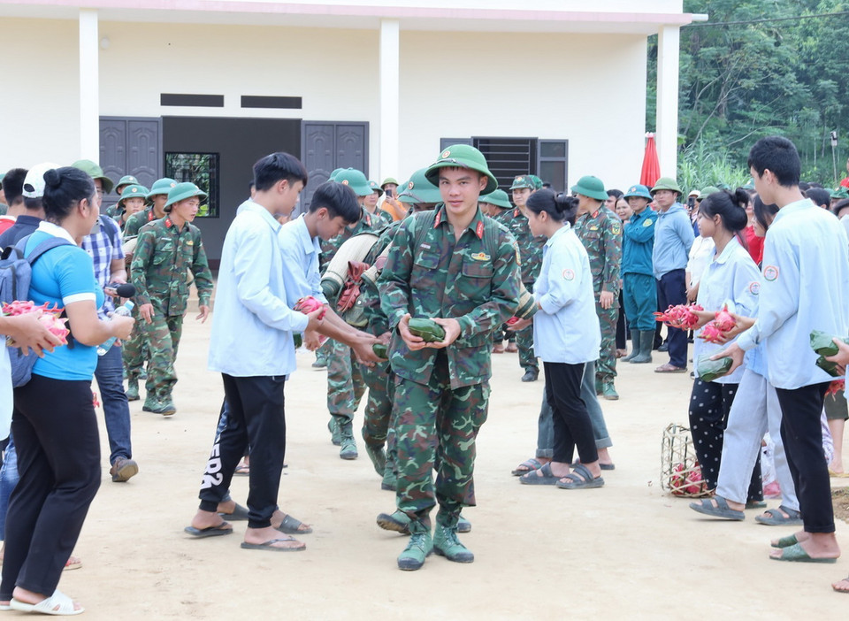 Người dân thôn Làng Nủ tặng những chiếc bánh chưng tự gói cho chiến sỹ trước khi về đơn vị. (Ảnh: TTXVN phát)