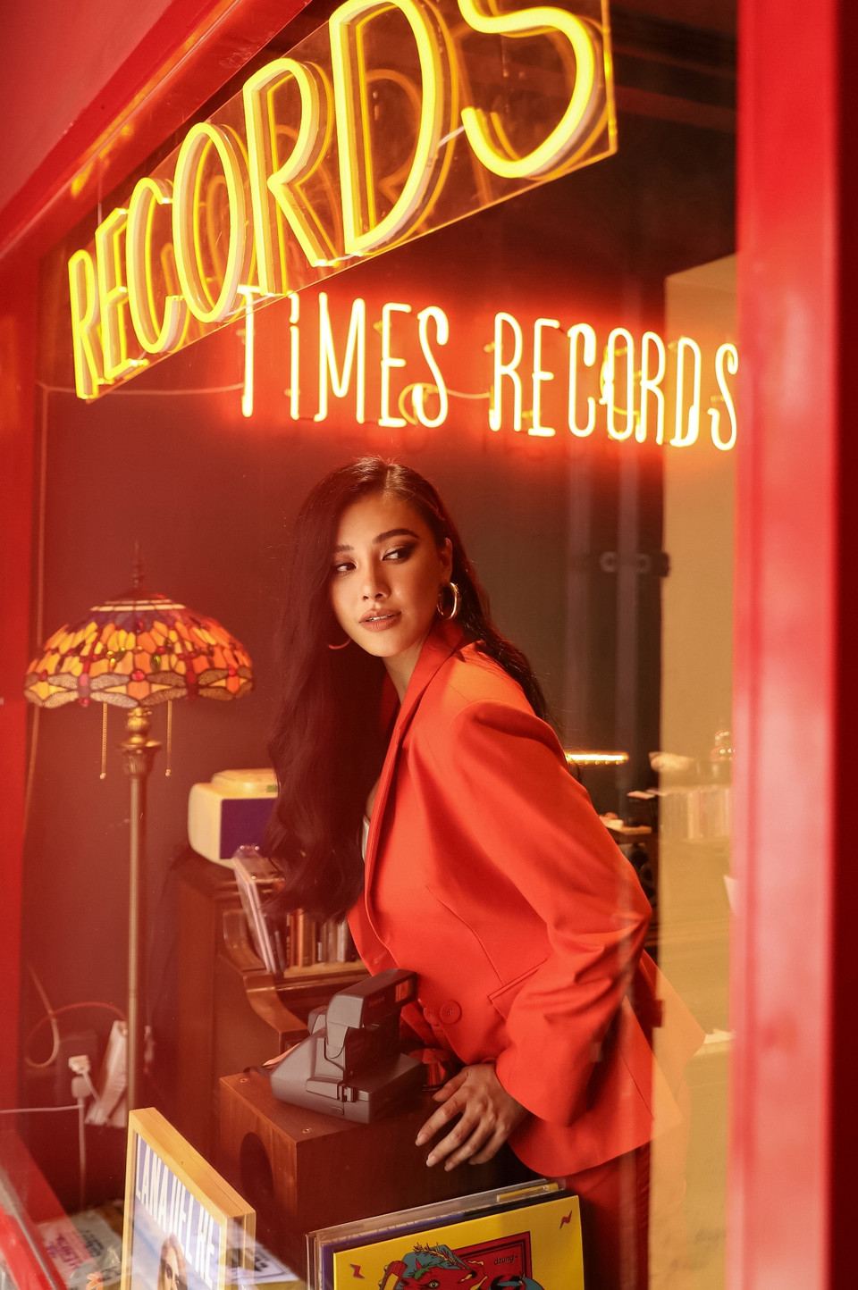 Với bộ ảnh này, Á hậu Kim Duyên bàn với êkíp chọn địa điểm chụp tại một tiệm băng đĩa mang hơi hướng cổ xưa. (Ảnh: Trí Nguyễn/Vietnam+)