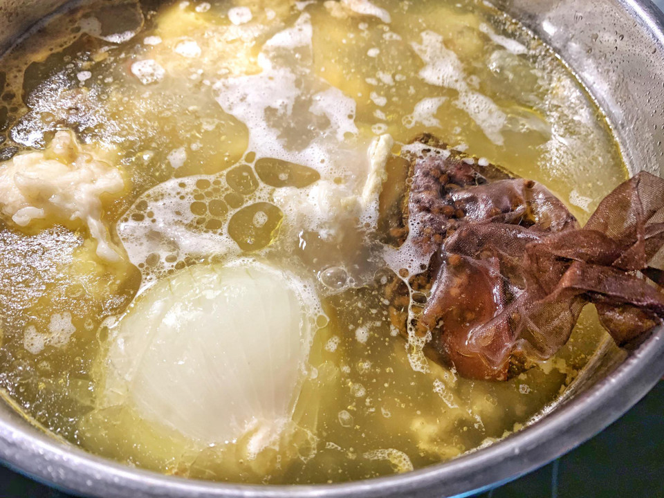 Sau khi hầm hành tây, gừng, sá sùng được 4-5 tiếng thì cho túi các loại hạt gia vị trên vào hầm cùng khoảng 2 tiếng, sau đó vớt cả túi hạt và xương ống ra. Cho vào nước dùng: đường phèn , muối, hạt nêm nêm nếm theo khẩu vị. Phở bò vị Hà Nội sẽ không nêm nước mắm vì nước mắm làm nước dùng có vị nồng. (Ảnh: Mai Mai/Vietnam+)