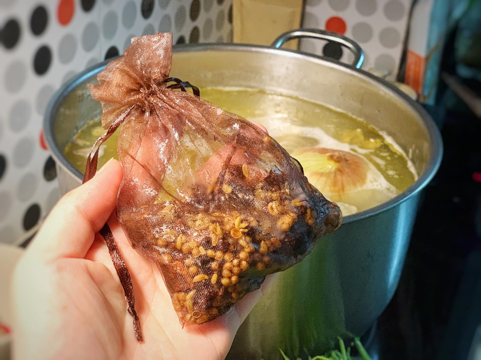 Cho các loại hạt gia vị vào túi trước khi cho vào nồi hầm xương. (Ảnh: Mai Mai/Vietnam+)