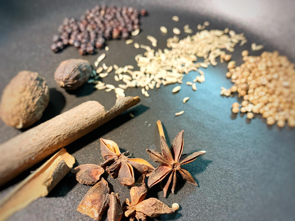 Cho đại hồi, tiểu hồi, quế, thảo quả, hạt mùi già, tiêu sọ vào chảo rang cho dậy mùi thơm. Chú ý không rang vàng quá sẽ làm đen màu nước dùng. Sau đó đem ngâm với nước sôi cho gia vị ra bớt màu đen và mùi, giúp nước dùng có hương thoang thoảng nhẹ nhàng, không bị nồng gây khó chịu. (Ảnh: Mai Mai/Vietnam+)