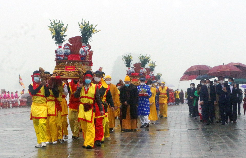 Tám bình nước lấy từ hồ Tam Chúc được buộc chặt nơ đỏ đặt lên kiệu do 8 thanh niên khiêng ngược lên các con dốc dựng đứng và hàng trăm bậc thang đặt vào các địa điểm: Tam Quan Nội, Điện Quán Âm, Điện Giáo Chủ, Điện Tam Thế, Chùa Ngọc. (Ảnh: Đại Nghĩa/TTXVN)