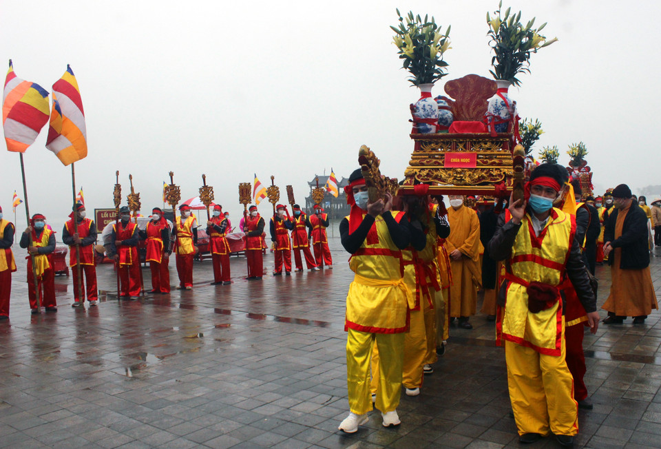 Tám bình nước lấy từ hồ Tam Chúc được buộc chặt nơ đỏ đặt lên kiệu do 8 thanh niên khiêng ngược lên các con dốc dựng đứng và hàng trăm bậc thang đặt vào các địa điểm: Tam Quan Nội, Điện Quán Âm, Điện Giáo Chủ, Điện Tam Thế, Chùa Ngọc. (Ảnh: Đại Nghĩa/TTXVN)