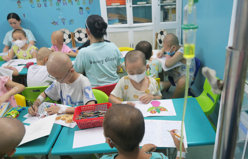 Bệnh nhi đi học với bàn tay còn gắn kim tiêm, dịch truyền. (Ảnh: Đinh Hằng/TTXVN)