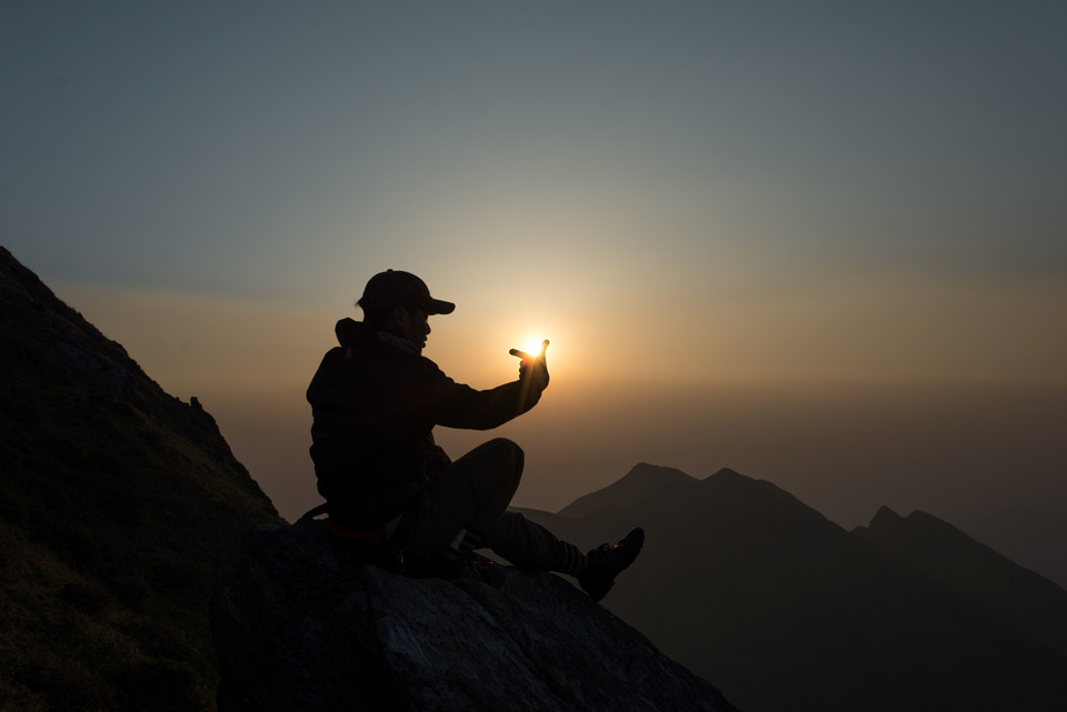 Mặt trời như đỏ rực như lòng đỏ trứng gà lơ lửng trên bầu trời, nhô dần khỏi những đỉnh núi cao sừng sững. (Ảnh: Đức Cương/Vietnam+)