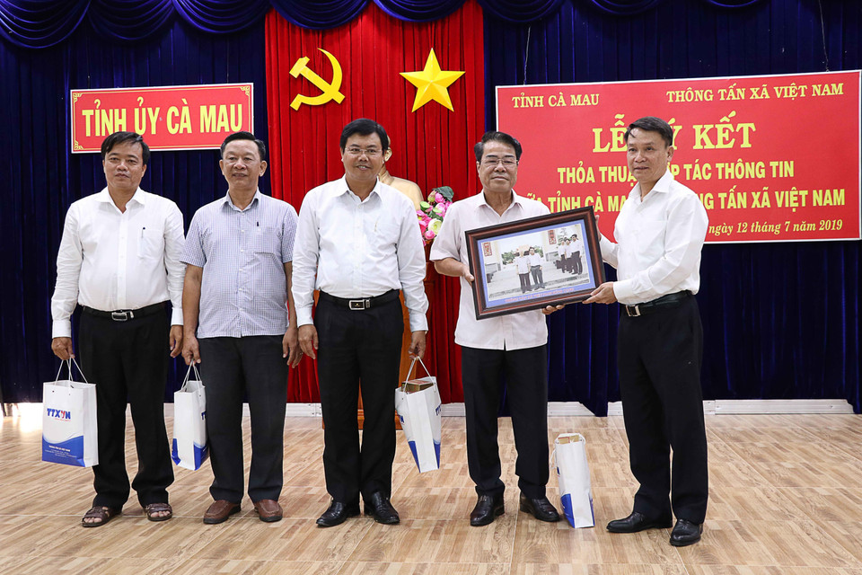 Tổng Giám đốc TTXVN Nguyễn Đức Lợi tặng quà lưu niệm cho các đồng chí lãnh đạo Tỉnh ủy Cà Mau. (Ảnh: Kim Há/TTXVN)