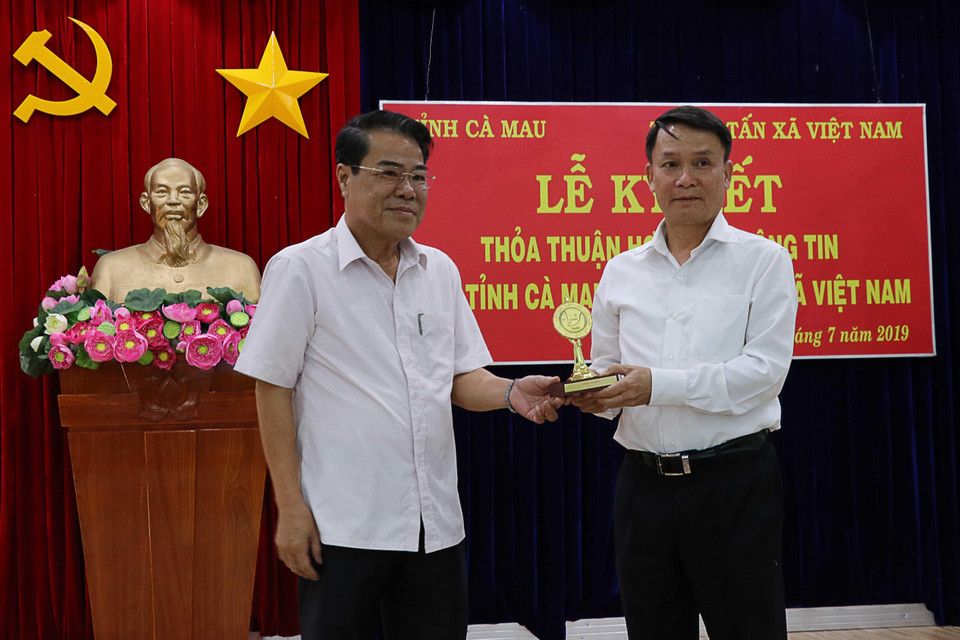 Bí thư Tỉnh ủy Cà Mau Dương Thanh Bình trao quà lưu niệm cho Tổng Giám đốc TTXVN Nguyễn Đức Lợi tại buổi lễ. (Ảnh: Kim Há/TTXVN)