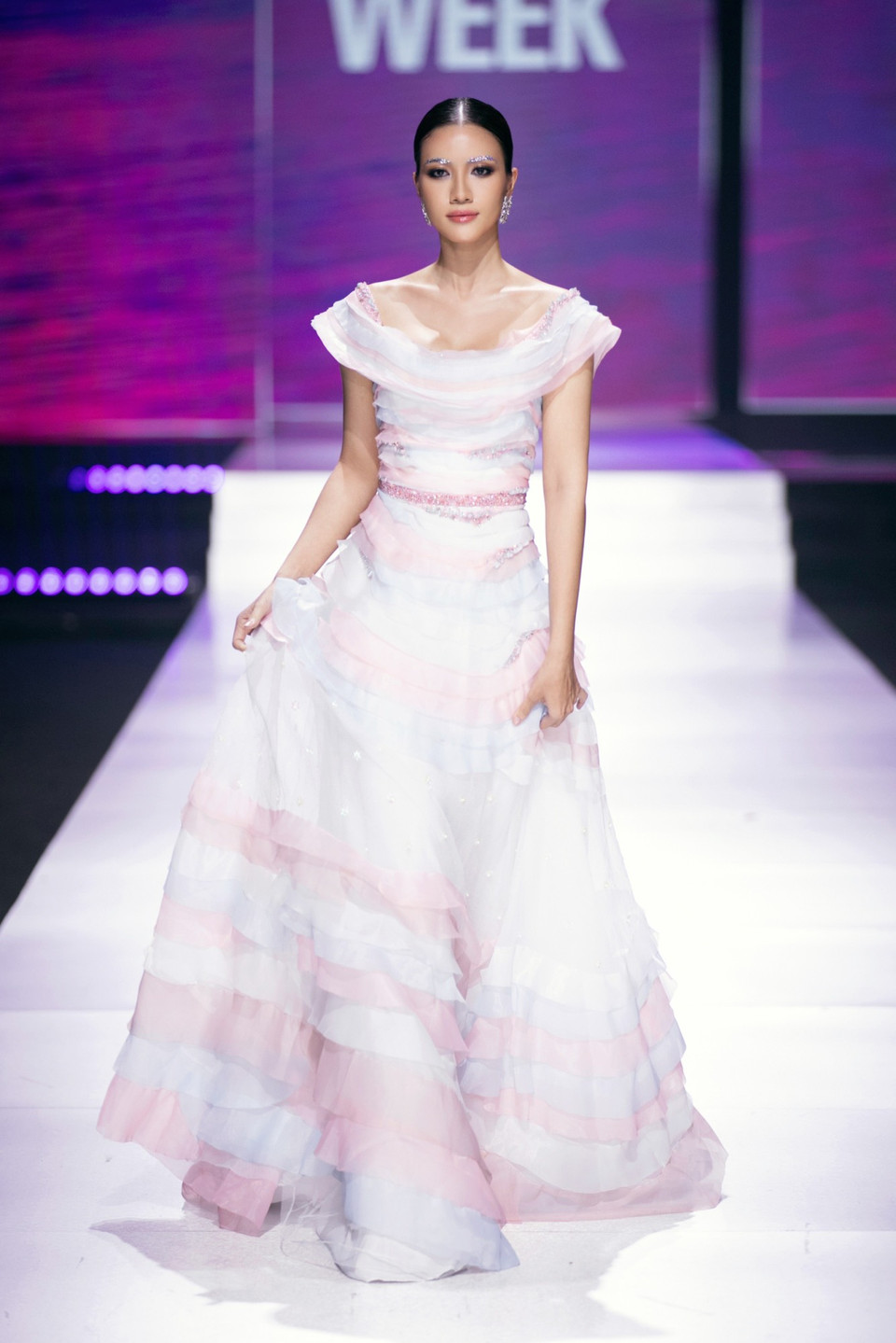 Sử dụng chất liệu vải organza và lụa tơ mềm mại, bay bổng tựa như áng mây bồng bềnh, các thiết kế nổi bật hơn cả khi được điểm xuyến bởi những chi tiết dệt, thêu tỉ mỉ và đính đá pha lê lấp lánh. (Ảnh: CTV/Vietnam+)