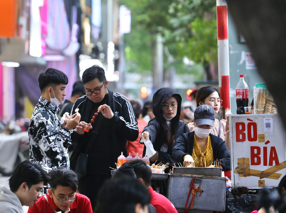 Nhiều người dân đã mặc thêm quần áo ấm khi nhiệt độ giảm mạnh. (Ảnh: Hoàng Hiếu/TTXVN)