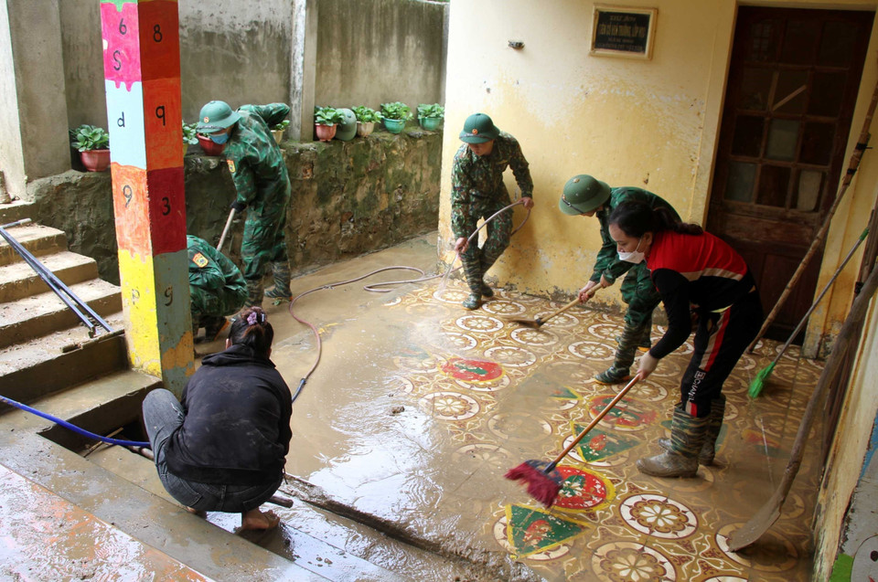 Cán bộ chiến sỹ bộ đội biên phòng Nghệ An cùng giáo viên, phụ huynh học sinh Trường mầm non xã Tà Cạ, huyện Kỳ Sơn, dọn dẹp, vệ sinh, phun tiêu độc khử trùng sẵn sàng đón học sinh trở lại trường sau mưa lũ. (Ảnh: Văn Tý/TTXVN)