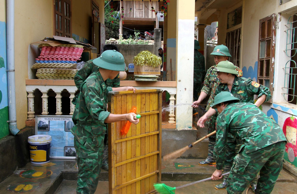 Cán bộ chiến sỹ bộ đội biên phòng Nghệ An cùng giáo viên, phụ huynh học sinh Trường mầm non xã Tà Cạ, huyện Kỳ Sơn, dọn dẹp, vệ sinh, phun tiêu độc khử trùng sẵn sàng đón học sinh trở lại trường sau mưa lũ. (Ảnh: Văn Tý/TTXVN)