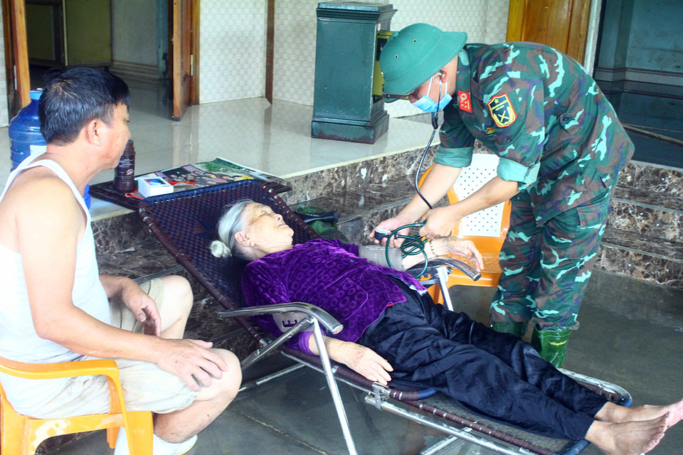 Cán bộ Quân y Sư đoàn 324 khám sức khỏe cho người già tại xã Thanh Mỹ, huyện Thanh Chương (Nghệ An).(Ảnh: Tá Chuyên/TTXVN)