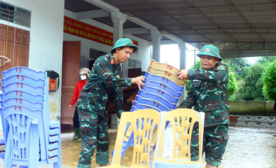 Cán bộ, nhân viên ban CHQS huyện Thanh Chương (Nghệ An) vận chuyển bàn ghế lau chùi tại thôn Mỹ Hương (xã Hưng Mỹ, huyện Thanh Chương, Nghệ An).(Ảnh: Tá Chuyên/TTXVN)