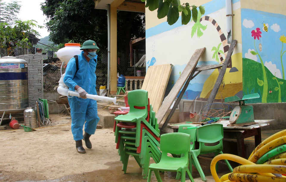 Cán bộ chiến sỹ bộ đội biên phòng Nghệ An cùng giáo viên, phụ huynh học sinh Trường mầm non xã Tà Cạ, huyện Kỳ Sơn, dọn dẹp, vệ sinh, phun tiêu độc khử trùng sẵn sàng đón học sinh trở lại trường sau mưa lũ. (Ảnh: Văn Tý/TTXVN)