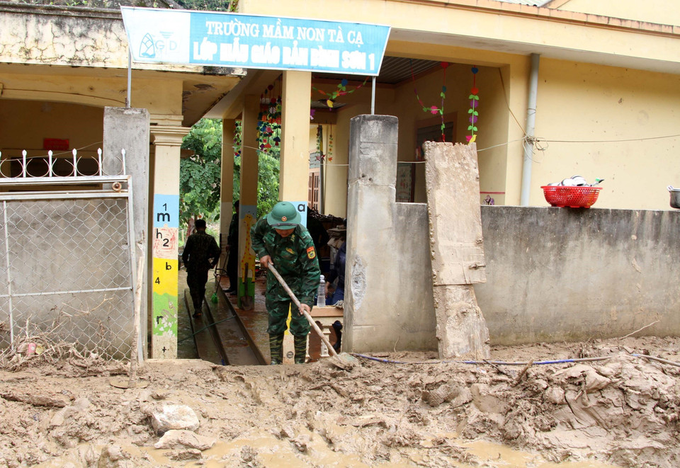 Cán bộ chiến sỹ bộ đội biên phòng Nghệ An cùng giáo viên, phụ huynh học sinh Trường mầm non xã Tà Cạ, huyện Kỳ Sơn, dọn dẹp, vệ sinh, phun tiêu độc khử trùng sẵn sàng đón học sinh trở lại trường sau mưa lũ. (Ảnh: Văn Tý/TTXVN)