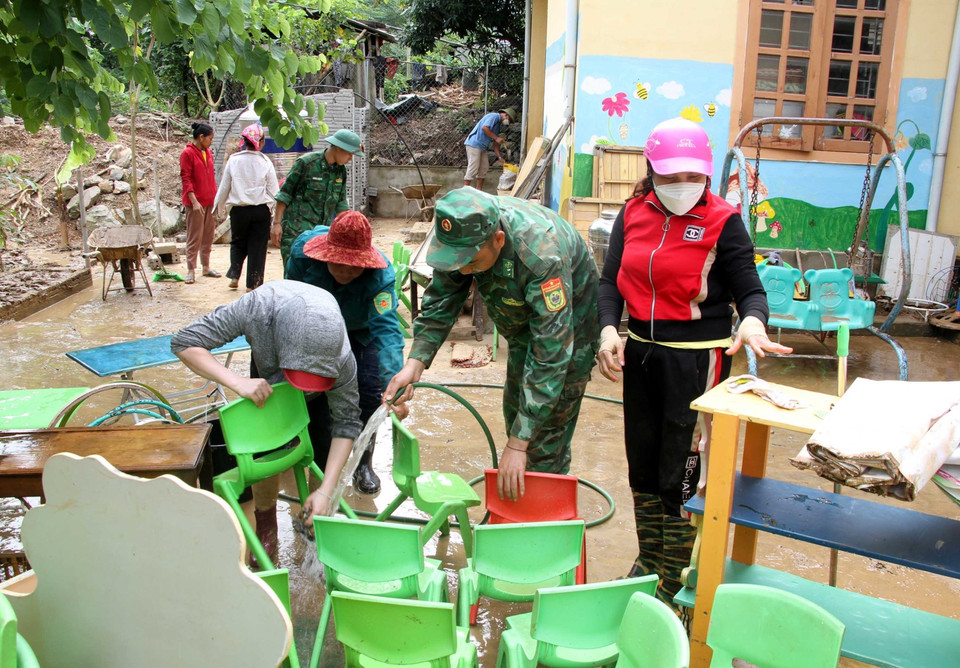 Cán bộ chiến sỹ bộ đội biên phòng Nghệ An cùng giáo viên, phụ huynh học sinh Trường mầm non xã Tà Cạ, huyện Kỳ Sơn, dọn dẹp, vệ sinh, phun tiêu độc khử trùng sẵn sàng đón học sinh trở lại trường sau mưa lũ. (Ảnh: Văn Tý/TTXVN)