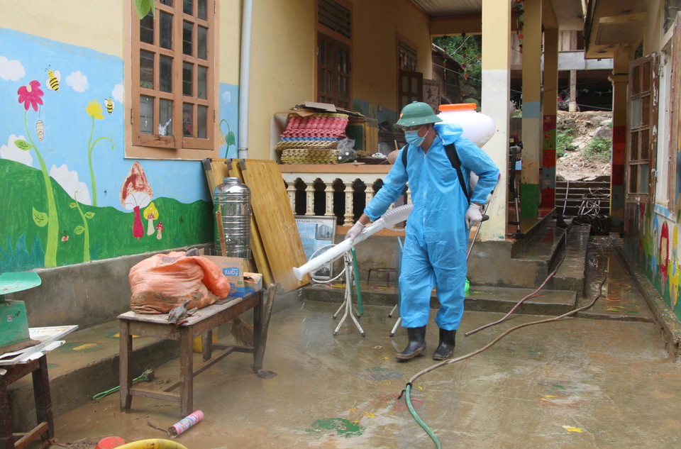 Cán bộ chiến sỹ bộ đội biên phòng Nghệ An cùng giáo viên, phụ huynh học sinh Trường mầm non xã Tà Cạ, huyện Kỳ Sơn, dọn dẹp, vệ sinh, phun tiêu độc khử trùng sẵn sàng đón học sinh trở lại trường sau mưa lũ. (Ảnh: Văn Tý/TTXVN)