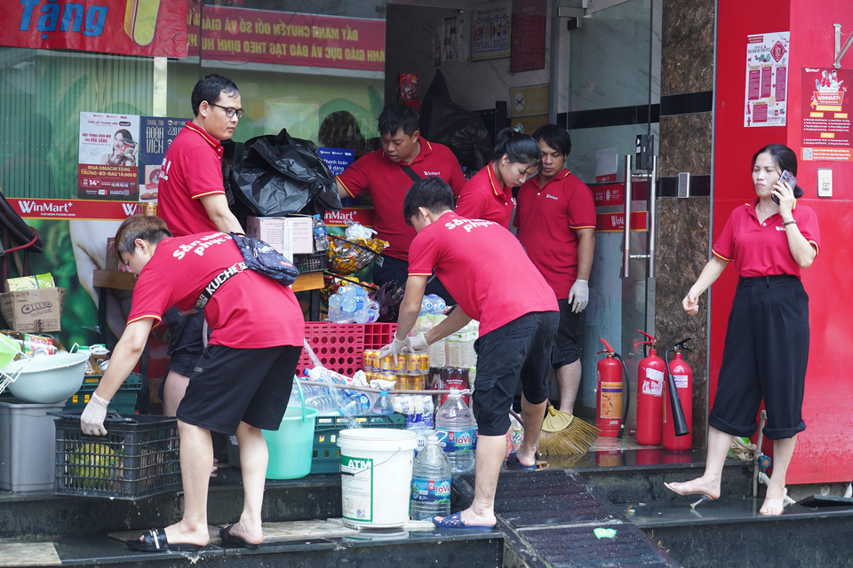 Ngay sau khi nước rút, bà con khu phố đã tất bật bắt tay vào công cuộc dọn dẹp, vệ sinh nhà cửa sau mưa lũ. (Ảnh: Việt Anh/Vietnam+)