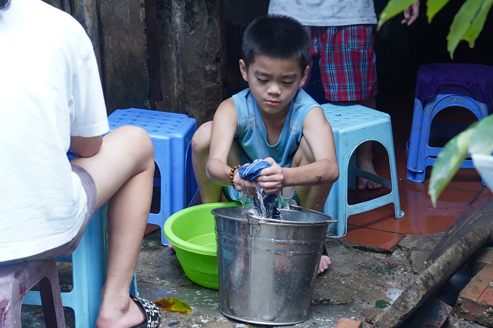 Các em nhỏ cũng "xắn tay" phụ giúp người lớn dọn dẹp nhà cửa. (Ảnh: Việt Anh/Vietnam+)