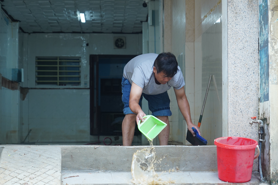 Người dân dùng cọ, chổi dọn nước bùn ra khỏi nhà. (Ảnh: Việt Anh/Vietnam+)