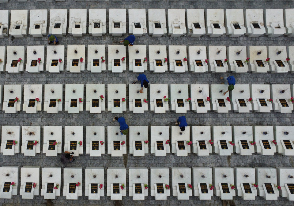 Thanh niên tình nguyện chăm sóc mộ phần các liệt sỹ đang yên nghỉ tại Nghĩa trang Liệt sỹ Quốc gia Vị Xuyên. (Ảnh: Hoàng Hiếu/TTXVN)