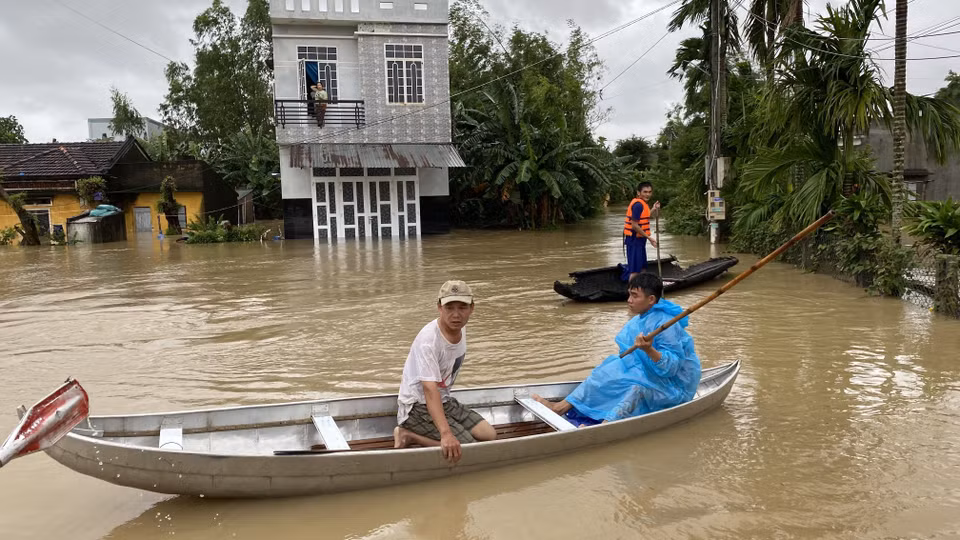 Người dân huyện Tuy Phước di chuyển bằng ghe thuyền. (Ảnh: Tường Quân/TTXVN)