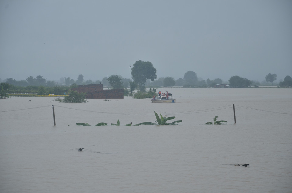 Lực lượng Cảnh sát Phòng cháy chữa cháy và cứu nạn cứu hộ-Công an tỉnh Gia Lai cứu hộ 14 hộ dân đến nơi an toàn. (Ảnh: Quang Thái/TTXVN)