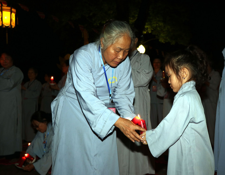  Thực hiện nghi lễ truyền đăng. (Ảnh: Mạnh Tú/TTXVN)