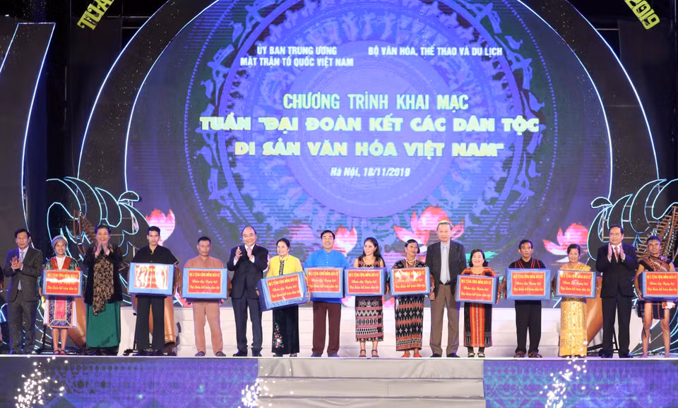 Thủ tướng Nguyễn Xuân Phúc cùng các lãnh đạo Đảng, Nhà nước trao quà cho đồng bào các dân tộc sống và sinh hoạt tại Làng. (Ảnh: Thống Nhất/TTXVN)