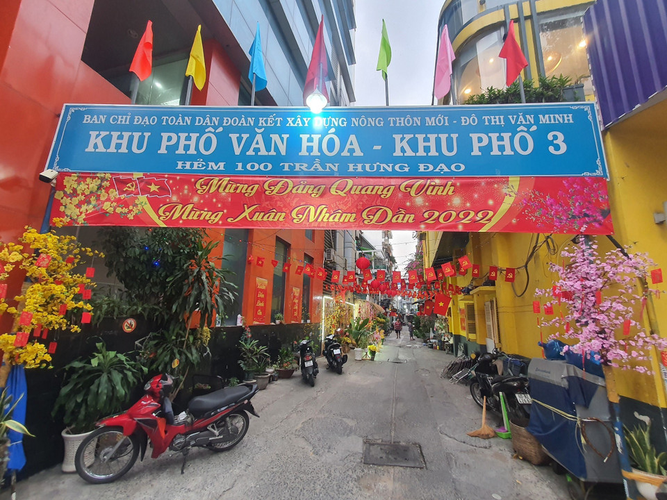 Khu phố 3, hẻm 100 đường Trần Hưng Đạo (Quận 1), nổi bật với nền tường màu vàng kèm các tiểu cảnh tranh trí Tết. (Ảnh: Thu Hương/TTXVN)