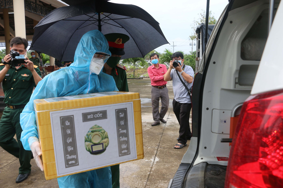 Đại diện Ban Chỉ huy quân sự huyện Châu Thành (An Giang) cùng chính quyền địa phương đã tiếp nhận, vận chuyển và bàn giao tro cốt người dân tử vong do dịch COVID-19 về tận nhà cho người thân, gia đình. (Ảnh: Công Mạo/TTXVN)