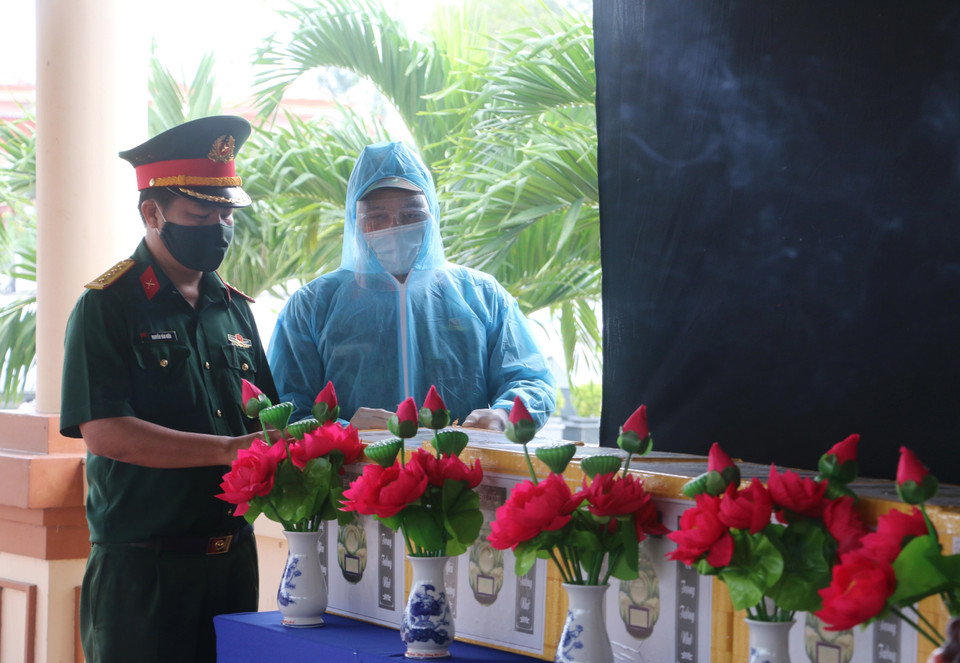 Đại diện Bộ Chỉ huy quân sự tỉnh An Giang và Đội K90 (Cục Chính trị, Bộ Tư lệnh Quân khu 9) kiểm tra số lượng, dang sách tro cốt người dân tử vong do dịch COVID-19. (Ảnh: Công Mạo/TTXVN)