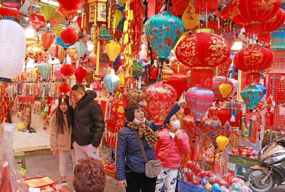 Khách lựa chọn, mua sắm đồ trang trí Tết tại phố Hàng Mã. (Ảnh: Trần Việt/TTXVN)