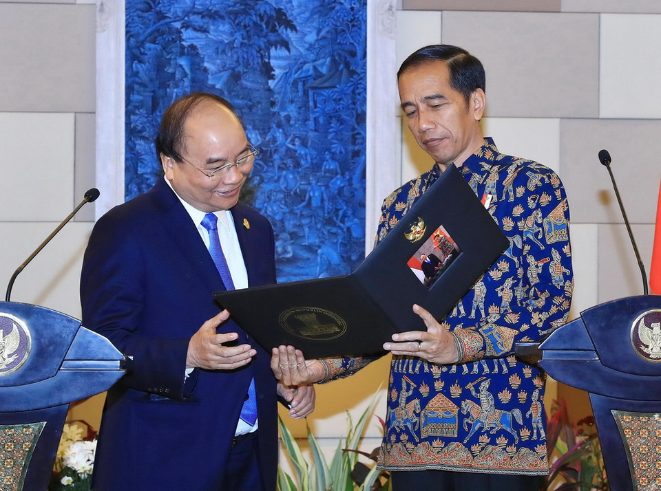 Tổng thống nước Cộng hòa Indonesia Joko Widodo tặng ảnh lưu niệm cho Thủ tướng Nguyễn Xuân Phúc tại cuộc gặp gỡ báo chí sau hội đàm. (Ảnh: Thống Nhất/TTXVN)