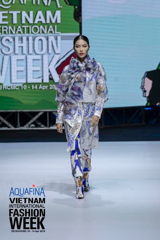 Chuyển tiếp từ các khung hình kỹ thuật số đến vải vóc, họa tiết đầy màu sắc, những hình ảnh được “tái bản” ở tùng váy xếp li đầy nữ tính, áo trench coat hay những chiếc khăn lụa. (Ảnh: BTC)